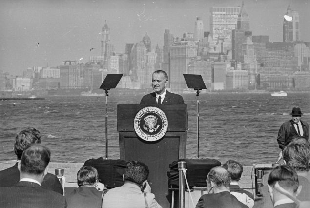 12th October 1965: American President Lyndon Baines Johnson (1908 - 1973) speaking after he had signed the new Immigration Bill at the foot of the Statue of Liberty. In the background is the New York skyline. (Photo by Harry Benson/Express/Getty Images)