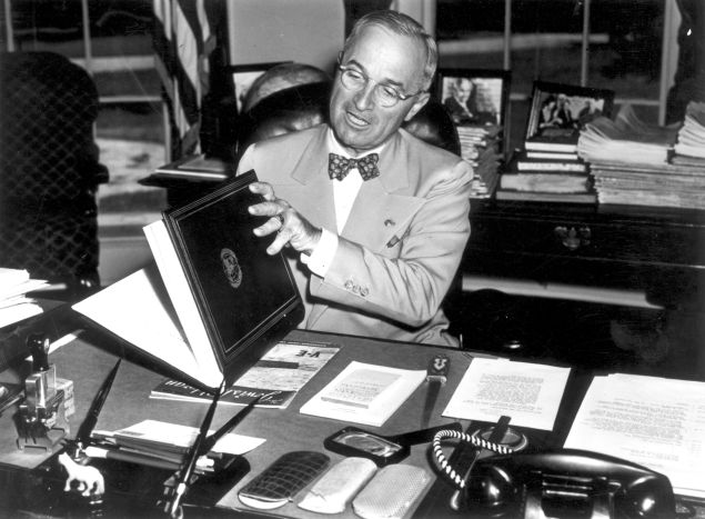 12th July 1945: The 33rd President of the United States Harry S Truman (1884 - 1972) examining the United Nations Charter in Washington. The UN Charter was drawn up and signed by representatives of 50 countries at the UN Conference on International Organization. (Photo by Fox Photos/Getty Images)
