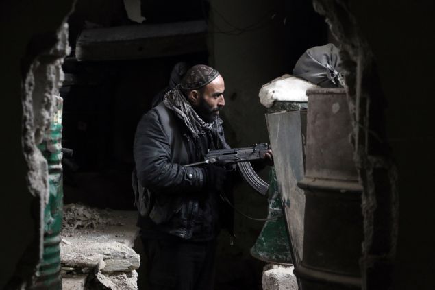 A fighter from the Jaish al-Islam (Islam Army), the foremost rebel group in Damascus province who fiercely opposed to both the regime and the Islamic State group, guards a position on the front line in Jobar, on the eastern edge of the Syrian capital on January 4, 2016. Jaish al-Islam has fought off both government forces and IS group jihadists in its Eastern Ghouta bastion, east of the capital. AFP PHOTO / AMER ALMOHIBANY / AFP / AMER ALMOHIBANY (Photo credit should read AMER ALMOHIBANY/AFP/Getty Images)