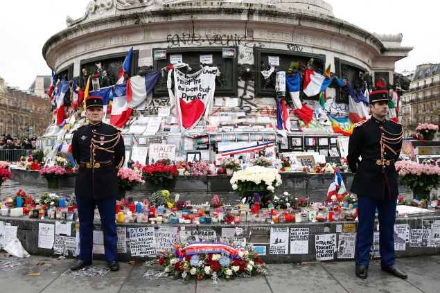 Republican guards stand beside a wreath of flowers placed by Paris' mayor and the French president at the foot of the Statue of Marianne during a remembrance rally after attacks on the Charlie Hebdo newspaper one year ago. (Photo: YOAN VALAT/AFP/Getty Images)