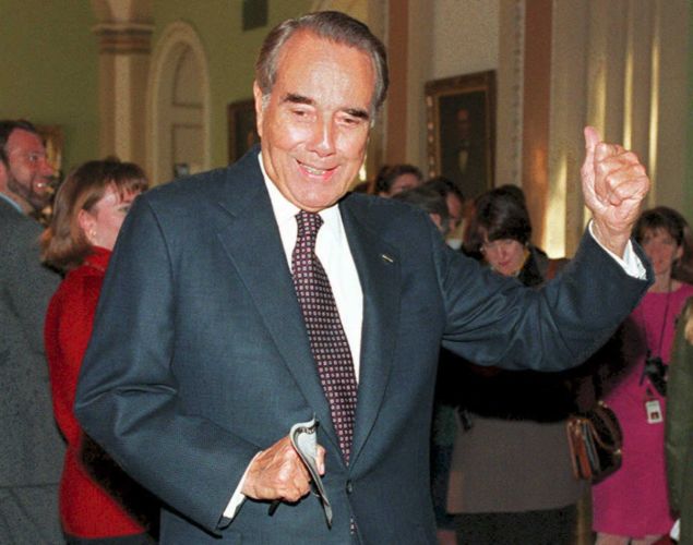 WASHINGTON, DC - DECEMBER 1: Sen. Robert Dole (R-KS), the expected Senate majority leader, signals to current Senate Majority Leader George Mitchell (D-ME) that it is his turn to talk to reporters, 01 December 1994, in the halls of the Capitol Building in Washington. Dole had just met with Treasury Secretary Lloyd Bentsen about the GATT agreement. (Photo credit should read ROBERT GIROUX/AFP/Getty Images)