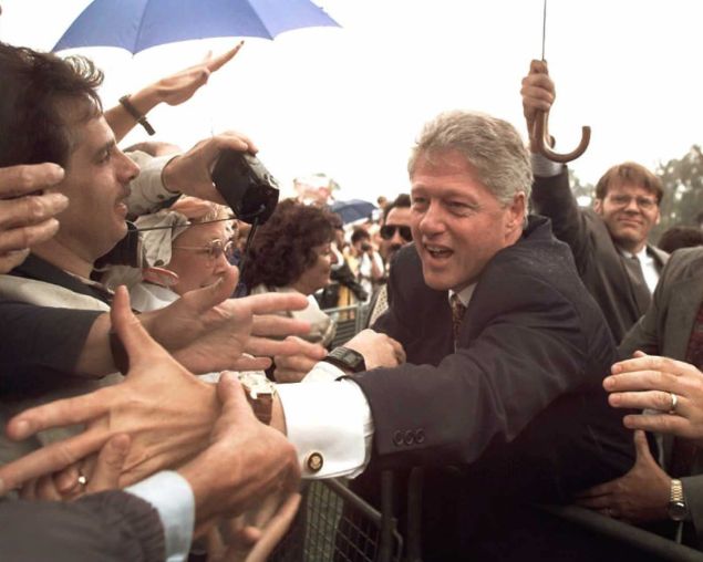 WESTLAND, MI - SEPTEMBER 17: US President Bill Clinton works the crowd after giving a speech at a rainy rally 17 September at John Glenn High School in Westland, Michigan. Clinton said earlier in the day that he enjoyed having Ross Perot in the presidential debates in 1992. Clinton made the comment after the presidential debate commission reccommended that Perot not be included in the debates. (Photo credit should read LUKE FRAZZA/AFP/Getty Images)