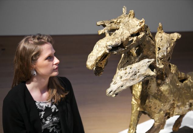 A woman poses with French sculptor Germaine Richier's masterpiece Le cheval à six têtes, grand, (1954-1956). (Photo: Bonhams)