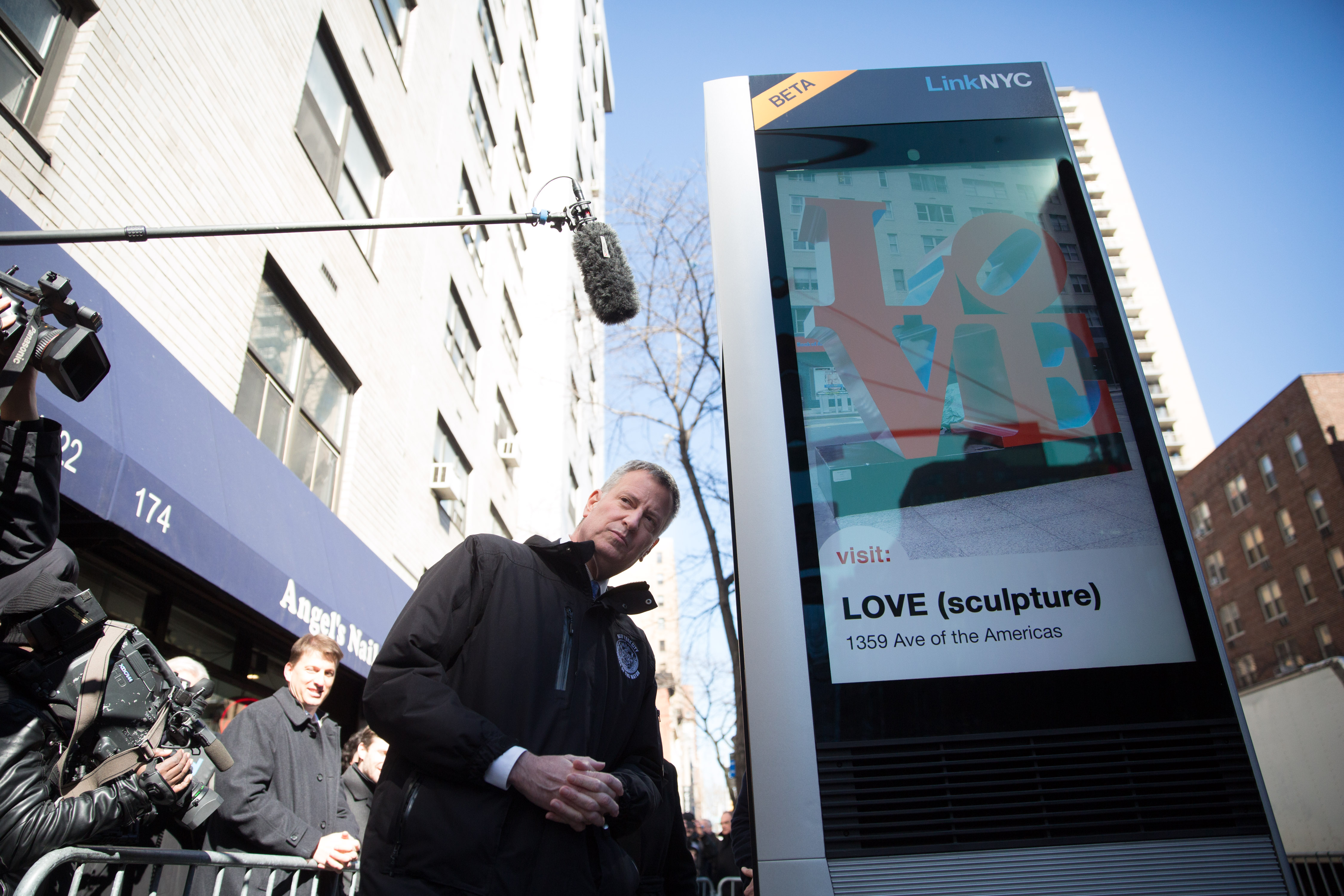 Mayor Bill de Blaisio makes a call on a new LinkNYC kiosk.
