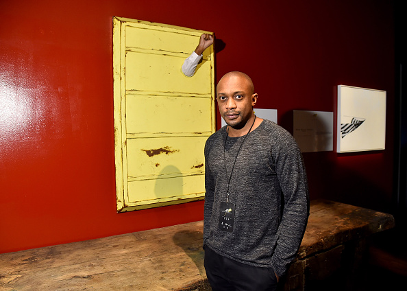 Artist Hank Willis Thomas poses next to his piece at Art For Social Justice, Usher Raymond IV, Daniel Arhsam and TIDAL debut Chains at Urban Zen on January 29, 2016 in New York City. (Photo by Michael Loccisano/Getty Images for Tidal)