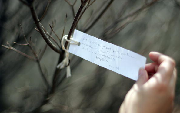 Washington, UNITED STATES: Japanese artist Yoko Ono, widow of Beatles member John Lennon, dedicates the "Wish Tree for Washington, DC" with the first wish: "Let's cover our planet with our love and make it a peaceful world for all of us and our offsprings" 02 April 2007 at the Hirshorn Museum's Sculpture Garden as part of "Yoko Ono: Imagine Peace" in Washington, DC. The Wish Tree series, which Ono began in the 1990s, encourages the public to become participants in the art-making process by inviting visitors to write wishes on paper and tie them to the tree. AFP PHOTO/Tim SLOAN