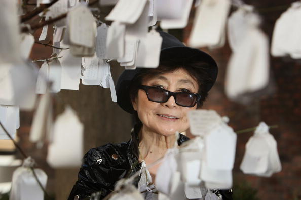 LIVERPOOL, UNITED KINGDOM - APRIL 04: Yoko Ono poses next to 'The Wish Tree', one of her art installations at The Bluecoat Display Centre on April, 2008 in Liverpool, England. The Wish Tree invites viewers to write their wishes on labels that are then fixed to the branches. Yoko Ono returned to perform and display her art at The Bluecoat 40 years after she first exhibited there in 1967 to celebrate the re-opening of the UK's oldest arts centre after a GBP 12.5 million refurbishment.