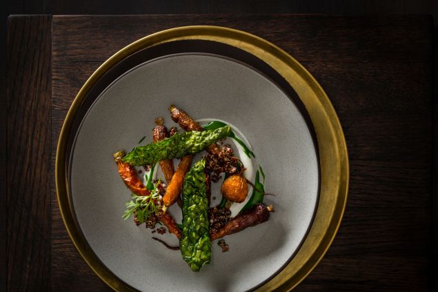 Roasted carrots over a yogurt gel and kale puree with red quinoa, chives and shallots and garnished with kale chips and green carrot tops prepared by Executive Chef/Owner Daniel Humm of NoMad Restaurant, NYC.