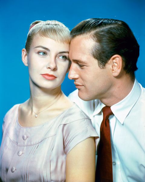 Joanne Woodward, US actress, and Paul Newman (1925-2008), US actor, in a studio portrait, against a blue background, issued as publcity for the film, 'The Long Hot Summer', 1958. The drama, directed by Martin Ritt (1914-1990), starred Woodward as 'Clara Varner', and Newman as 'Ben Quick'.