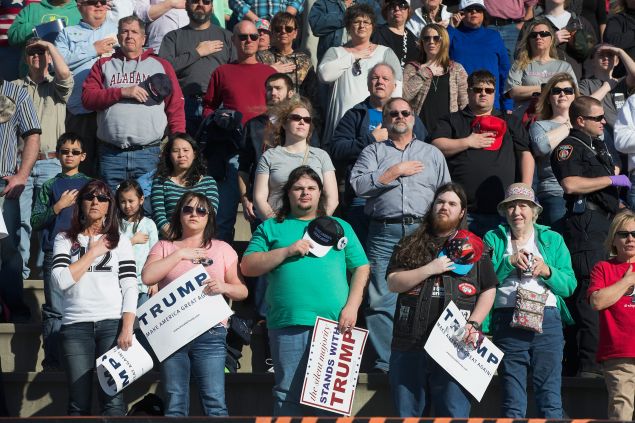 Guests listen to the national anthem during a campaign rally for Republican presidential candidate Donald Trump at the Madison City Schools Stadium on February 28, 2016 in Madison, Alabama. Trump is in Alabama ahead of the Super Tuesday primaries March 1.