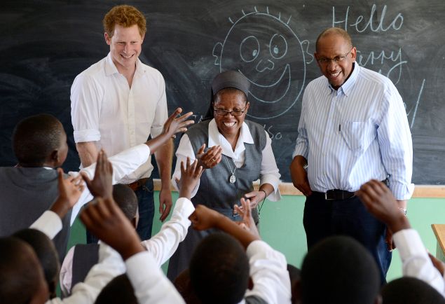 Britain's Prince Harry (L) flanked by Sister Victoria Mota (C) and Prince Seeiso, the younger brother of King Letsie of Lesotho, interacts with pupils at the Kananelo Centre for the Deaf on February 27, 2013 in Maseru. Prince Harry visited his charity projects in Lesotho on February 27 during his return visit to the southern African kingdom. The projects work with Sentebale, an organisation which Harry set up with Seeiso. The third-in-line to the British throne will travel to Johannesburg in neighbouring South Africa in the afternoon for a fund-raising gala dinner. AFP PHOTO / STEPHANE DE SAKUTIN 