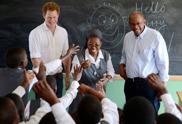 Britain's Prince Harry (L) flanked by Sister Victoria Mota (C) and Prince Seeiso, the younger brother of King Letsie of Lesotho, interacts with pupils at the Kananelo Centre for the Deaf on February 27, 2013 in Maseru. Prince Harry visited his charity projects in Lesotho on February 27 during his return visit to the southern African kingdom. The projects work with Sentebale, an organisation which Harry set up with Seeiso. The third-in-line to the British throne will travel to Johannesburg in neighbouring South Africa in the afternoon for a fund-raising gala dinner. AFP PHOTO / STEPHANE DE SAKUTIN