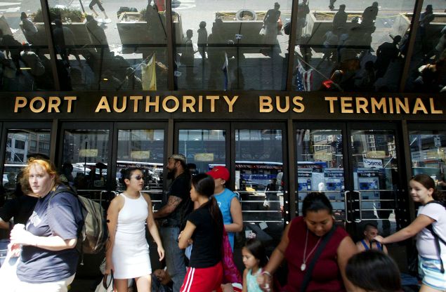 Stranded travellers gather outside the closed Port Authority Bus Terminal during a massive blackout August 
