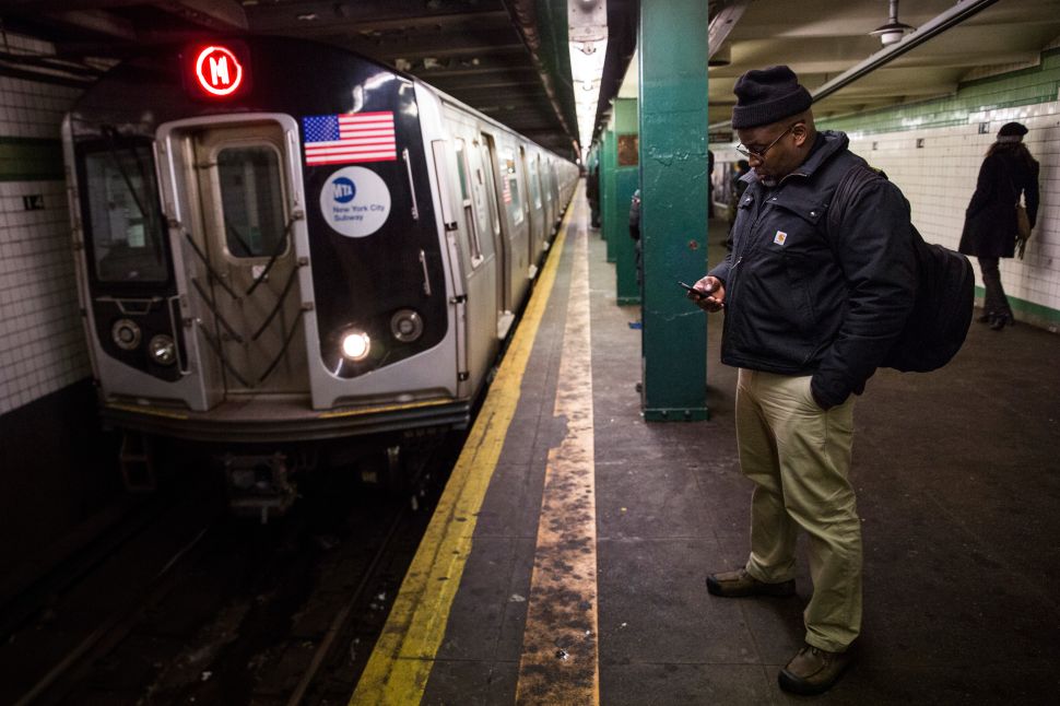 A man waits for a downtown M train. (Photo by Andrew Burton/Getty Images)