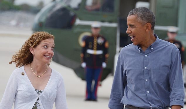 US President Barack Obama chats with DNC chair Debbie Wasserman Schultz as he makes his way to Air Force One shortly before departing from Miami International Airport in Miami on April 22, 2015.