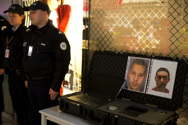 Police officers stand next to the wanted notice of terrorist Salah Abdeslam (L) and Mohamed Abrini on December 3, 2015 at the Roissy-Charles-de-Gaulle airport in Roissy-en-France, outside Paris. 