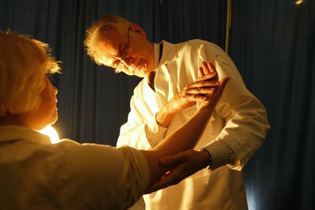 A doctor from the American Academy of Dermatology performs a free cancer screening on a patient.