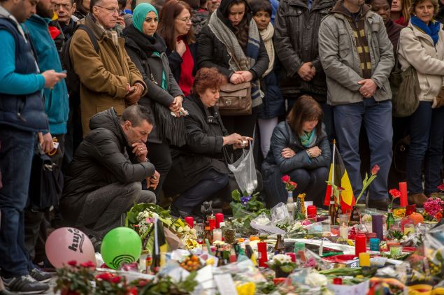 People gather at a makeshift memorial in front of Brussel's Stock Exchange.