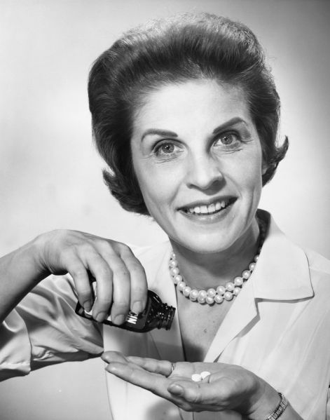 Woman pouring pills from bottle.