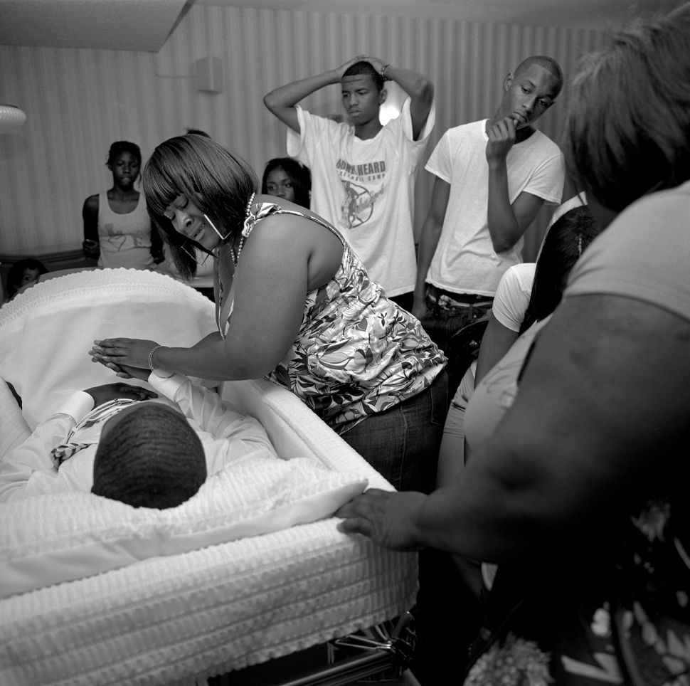 Britta McNeal cries as she sees her son for the first time after he was shot to death. Chaise Sherrors, 17, was shot and killed on Detroit's East Side just weeks after his good friend JeíRean Nobles was shot to death in the same neighborhood. McNeal lost her 14-year-old son a year earlier, also shot. Detroit's East Side is the poorest, most violent part of the nationís poorest, most violent big city. Chaise Sherrors was giving a haircut on a porch when he was shot. Summary: A Detroit Requiem DetroitÖthe word alone incites many emotions within Americaís conscience.† Detroit was the epicenter for financial equality in the U.S., the home front for the ideal of well-paying jobs for the masses and a political force behind a strong middle class.† Henry Ford made Detroit a boomtown.† Five decades after he started, the boom began to bust.† Many reasons are at the heart of Detroitís decline: postwar industrial policies, urban planning, the 1967 race riots, UAW and auto industry management, Detroitís political cronyism, Clinton era trade deals, and quite possibly the mobility of the automobile itself.† It was the 1950ís when Detroit began the long decay that has brought the city to its present state, a time when Detroit, and America, was at its peak. Today, Detroit is Americaís poorest large city.† To avoid being the nationís perpetual murder capital, the police began cooking stats.† In 2008, they claimed 306 homicides ñ until The Detroit News discovered that there were actually 375.† In more than 70 percent of murders in Detroit, the killer got away with it.† Detroitís East Side is now the poorest, most violent quarter of Americaís poorest, most violent big city.† The illiteracy, child poverty, and unemployment rates hover around 50 percent.† The shooting death of seven-year-old Aiyana Stanley-Jones by police on Detroitís East Side brought national attention to this quarter over the summer of 2010.† But as the spotlight