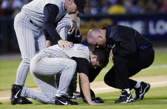 ST. LOUIS - SEPTEMBER 23: Manager Bob Brenly of the Arizona Diamondbacks and team trainer Paul Lessard check on third baseman Chris Donnels #18 after Donnels suffered a mild concussion while fielding a bunt in the third inning of the MLB game against the St. Louis Cardinals on September 23, 2002 at Busch Stadium in St. Louis, Missouri. The St. Louis Cardinals beat the Arizona Diamondbacks 13-1. (Photo by Elsa/Getty Images)