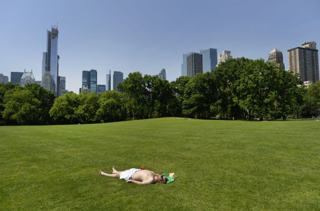 A man takes advantage of the hot weather to sun bathe in the Sheep Meadow in Central Park on May 30, 2013 in New York City. (