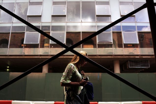 A woman walks by a building being constructed in DUMBO, an acronym for Down Under the Manhattan Bridge Overpass, section of Brooklyn on August 19, 2014 in the Brooklyn borough of New York City. Brooklyn, once a quiet and affordable borough across from Manhattan, is now home to some of the most ambitious projects in New York City. The Atlantic Yards development project, the Brooklyn Bridge Park and the building of residential towers in downtown Brooklyn are just a few of the development projects quickly transforming the borough. In the first half of 2014 alone total investment property sales in Brooklyn rose 38 percent from the first half of 2013 to 884.