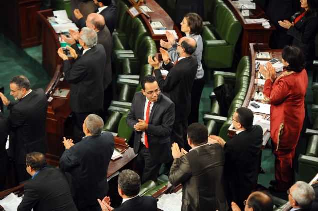 Tunisian members of parliament attend a ceremony to sign the new constitution at the National Constituent Assembly on January 27, 2014. Tunisia's leaders signed the new constitution adopted by lawmakers during the night, a key goal of the revolution three years ago that touched off the Arab Spring. The historic document, seen as one of the most modern in the Arab world.