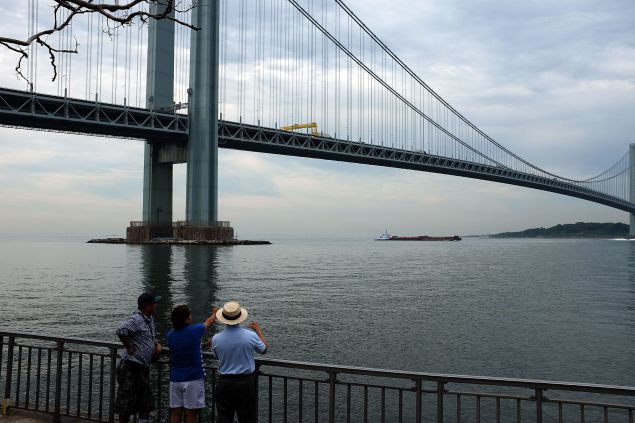 People on the Brooklyn side of the Verrazano Bridge stare out at Staten Island. 