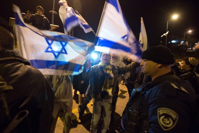 Israeli settlers protest outside their settlement of Kiryat Arba in the southern West Bank after a suspected Palestinian attacker stabbed to death a woman at her home in the Otniel settlement on January 17, 2016. A Palestinian broke into a West Bank Jewish settlement and stabbed Dafna Meir, a hospital nurse and mother of six, to death in her home, the Israeli army said, the first such incursion in a months-long wave of violence.