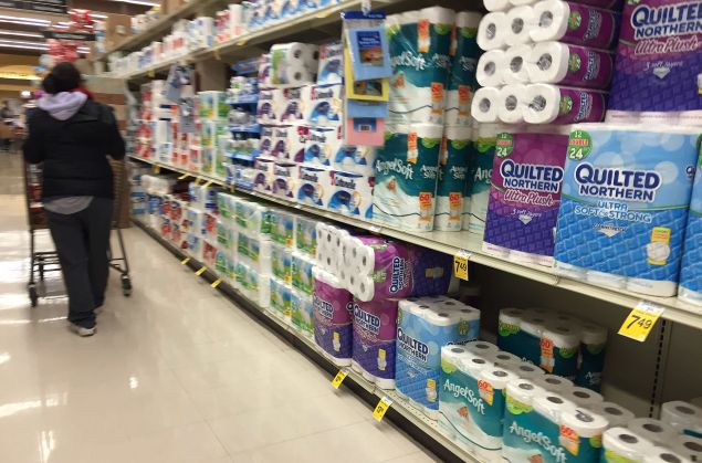 A shopper pushes a cart down the toilet paper aisle at Safeway in Bowie, Maryland, on January 20, 2016, as weather forecasts predict an incoming blizzard to the area. / AFP / JIM WATSON