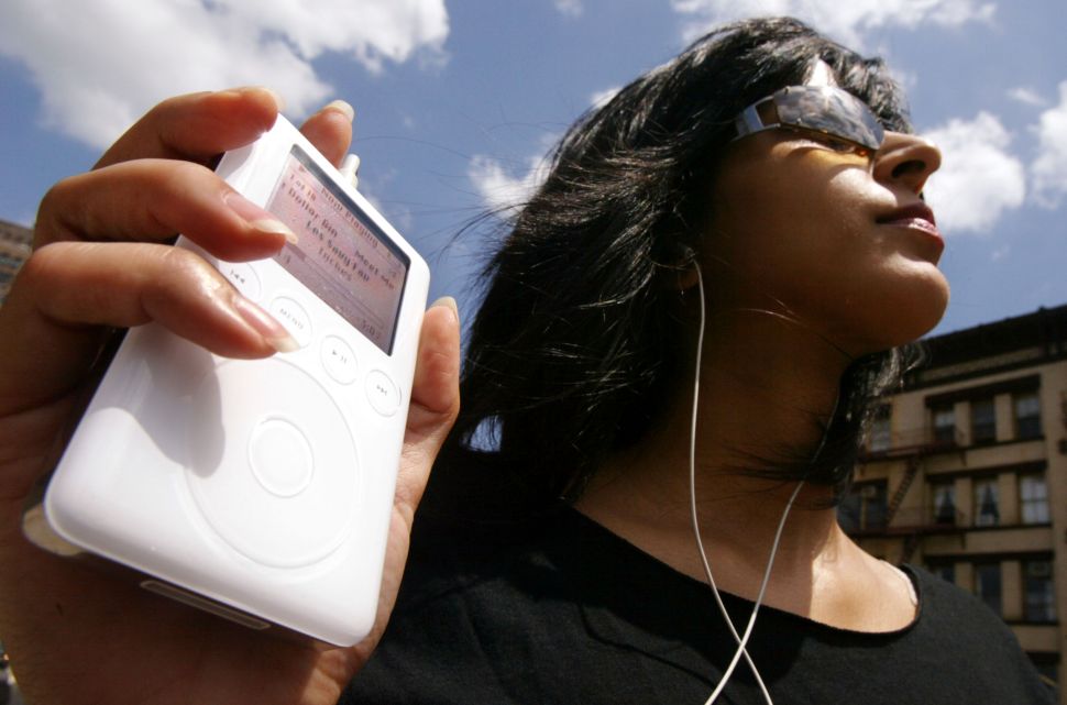 NEW YORK - JULY 15: Keeno Ahmed listens to her iPod mini digital music player July 15, 2004 in New York City. Apple Computer Inc. reported quarterly earnings that more than tripled, fueled by sales of its iPod digital music players.
