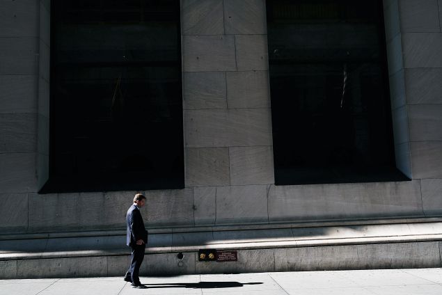 A man walks by the New York Stock Exchange (NYSE) along Wall Street on March 21, 2016 in New York City. Following a strong week for US stocks, the Dow Jones industrial average was down slightly in morning trading.