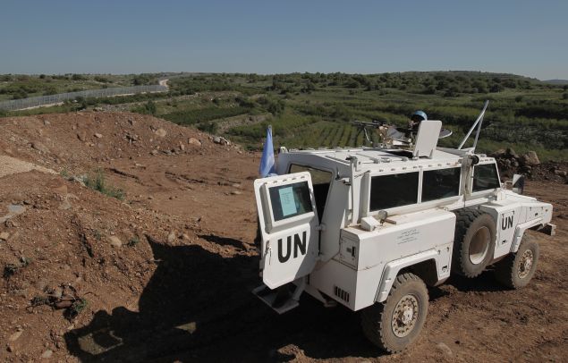 A peacekeeper of the United Nations Disengagement Observer Force (UNDOF) holds a position near the border with Syria in the Israeli-occupied sector of the Golan Heights on April 17, 2016.