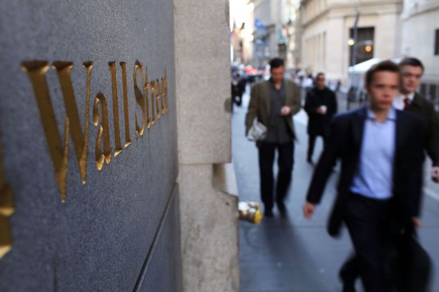 People walk along Wall Street in the financial district on April 19, 2010 in New York City.