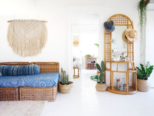 A hand-knit macrame from Australia hangs on the wall; a vintage rattan bar invites guests to don a hat.