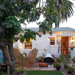 String lights and lanterns adorn the front yard of the cozy cottage.