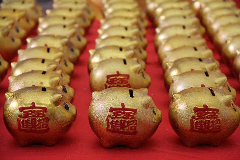 BINZHOU, CHINA - JANUARY 01: (CHINA OUT) Golden piggy banks pose the "2016" at a furniture market for lottery to celebrate new year on January 1, 2016 in Binzhou, Shandong Province of China. Citizens who purchase commodities from the furniture market will get a lottery chance and lucky men will gain a golden piggy bank.