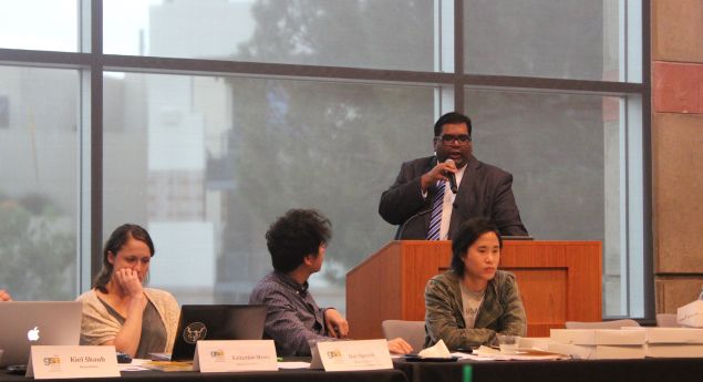 UCLA graduate student president Milan Chatterjee, standing, defends himself against accusations brought by Katherine Myers, first from left.