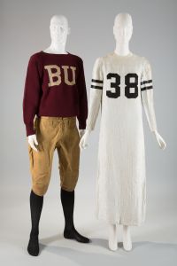 Man's football knickers with a maroon wool knit sweater with letters BU knit on center front next to a football jersey long sleeve evening dress