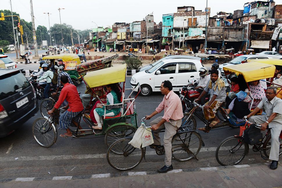 Indian cyclist Sushil Kumar, 41, holds onto the bars of his bicycle as he joins other commuters in cars, buses, auto rickshaws and motor bikes at a traffic stop in New Delhi on November 1, 2013. Trucks and buses, often driven with arrogance bordering on hostility, top the pyramid, followed by cars and auto-rickshaws. Cyclists are above the widely ignored pedestrian, but below cows. Sushil Kumar leaves his home at 6am every morning for his job in the telecoms ministry where he is paid 5,500 rupees (95 dollars) a month by a private contractor -- less than the minimum wage. His route of 24 kilometres (15 miles) takes him an hour and a half to complete from his home in the tough Delhi suburb of Ghaziabad, past camel-pulled carts and potholes, and beyond rows of mushrooming apartment blocks. He travels about 1,000 kilometres each month.