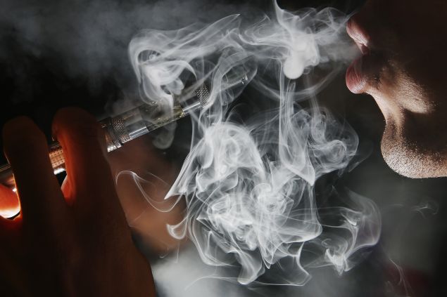 Man smoking an E-Cigarette at the V-Revolution E-Cigarette shop in Covent Garden on August 27, 2014 in London, England.