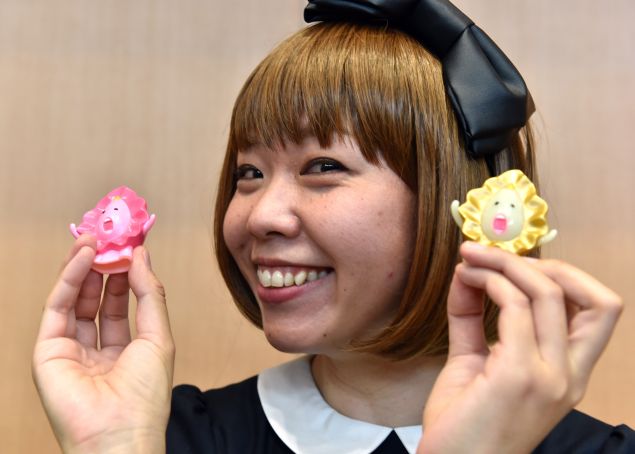 Japanese artist Megumi Igarashi, who calls herself Rokude Nashiko -- offensive slang which loosely translates as "reprobate child" -- shows small mascots shaped to represent a vagina, at a press conference after the first hearing of her trial in Tokyo on April 15, 2015. Igarashi, who has created genital-inspired artworks and was arrested last December on obscenity charges for distributing 3D scans of her own genitals, plead not guilty during the first hearing of her trial at the Tokyo district court.