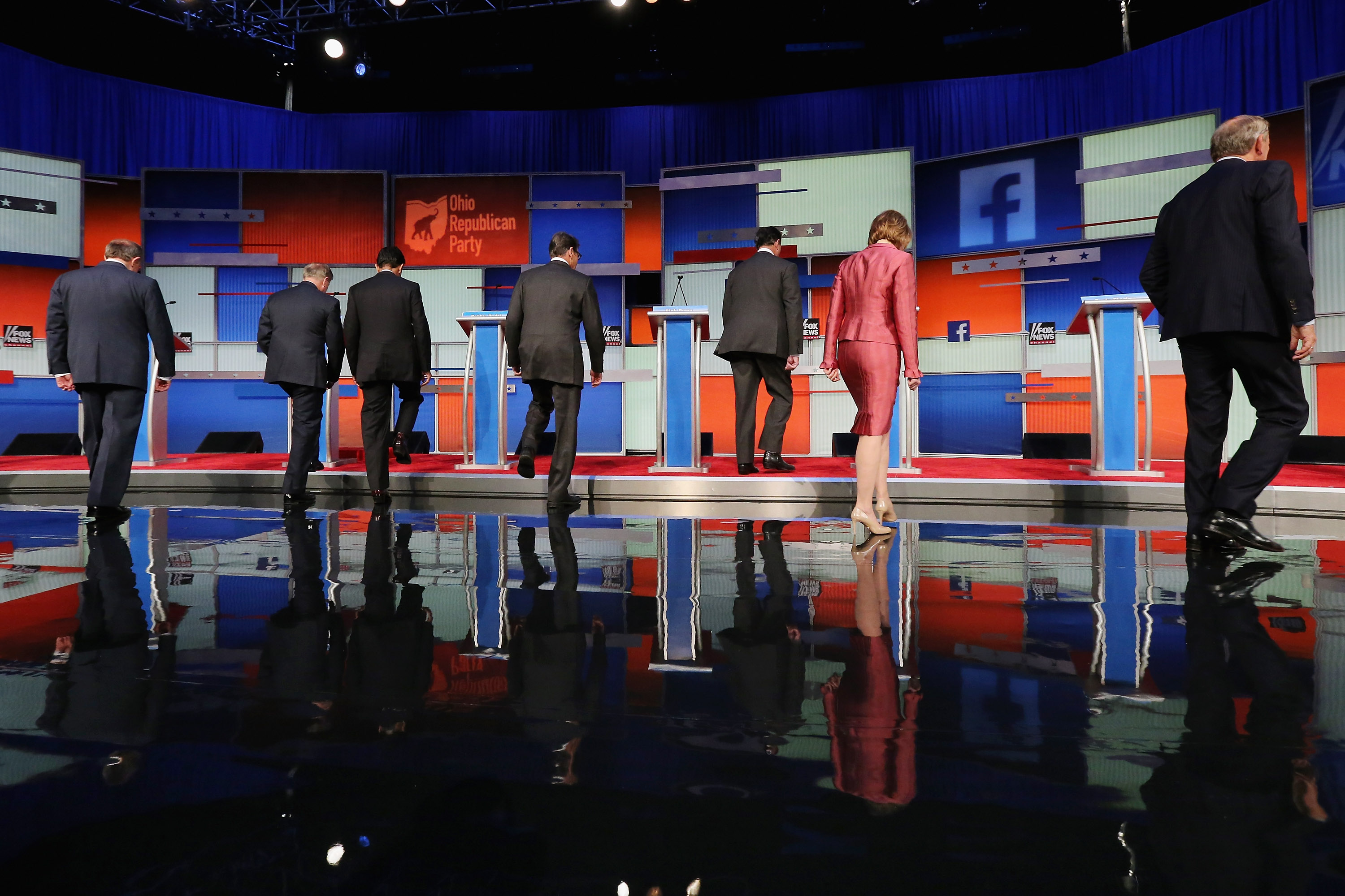 Republican presidential candidates (L-R) Jim Gilmore, Sen. Lindsey Graham (R-SC), Louisiana Gov. Bobby Jindal, Rick Perry, Rick Santorum, Carly Fiorina and George Pataki take their podiums at the beginning of a presidential forum hosted by FOX News and Facebook at the Quicken Loans Arena August 6, 2015 in Cleveland, Ohio. The seven GOP candidates were selected to participate in the forum based on their rank in an average of the five most recent national political polls.