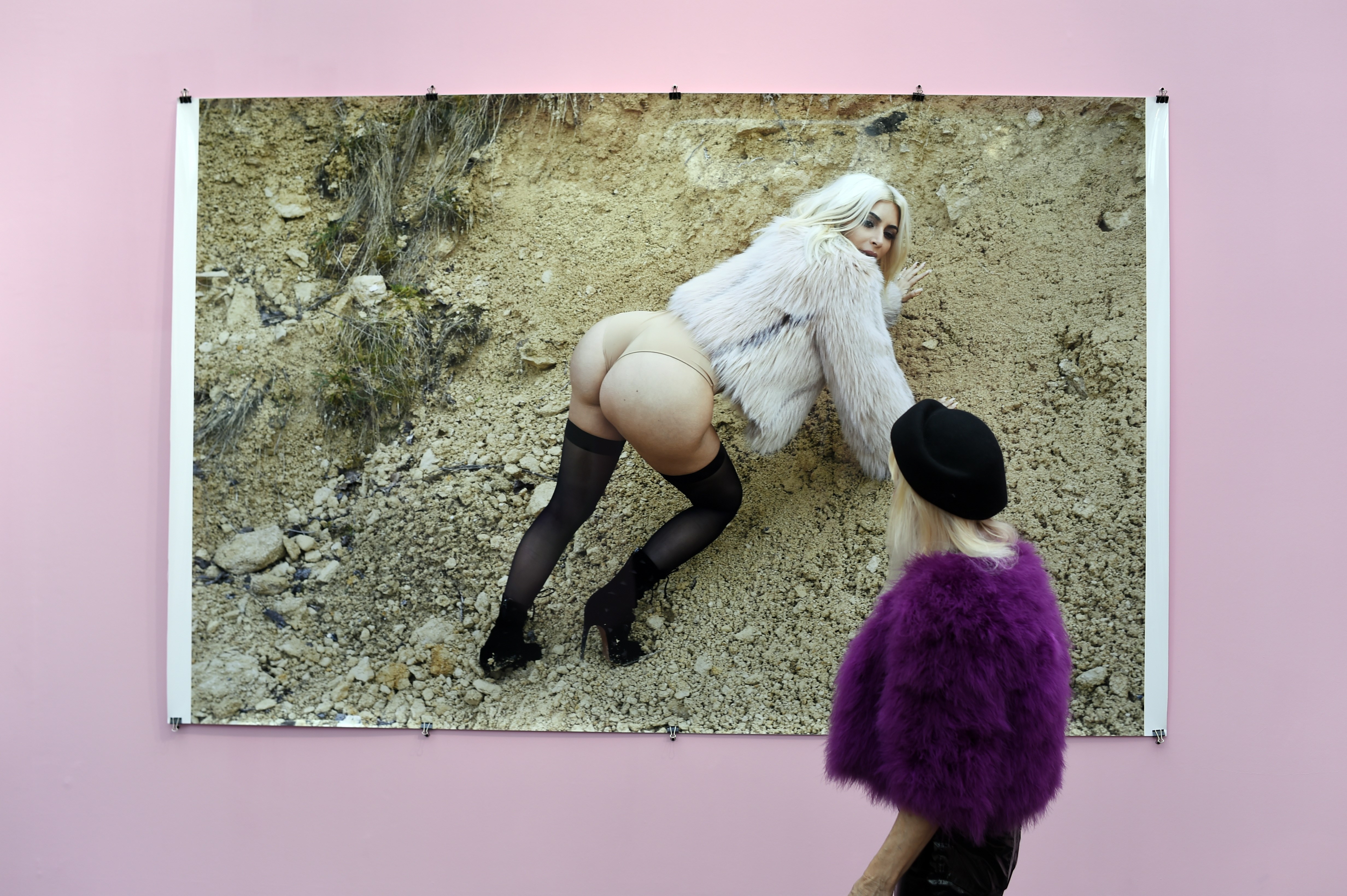 A visitor watches a photo of reality television star Kim Kardashian by German photographer Juergen Teller during the opening of the 19th edition of the Paris Photo Fair, the international fina art photography event that hosts leading galleries and artbook dealers, at the Grand Palais in Paris on November 11, 2015. The fair runs through November 12-15.