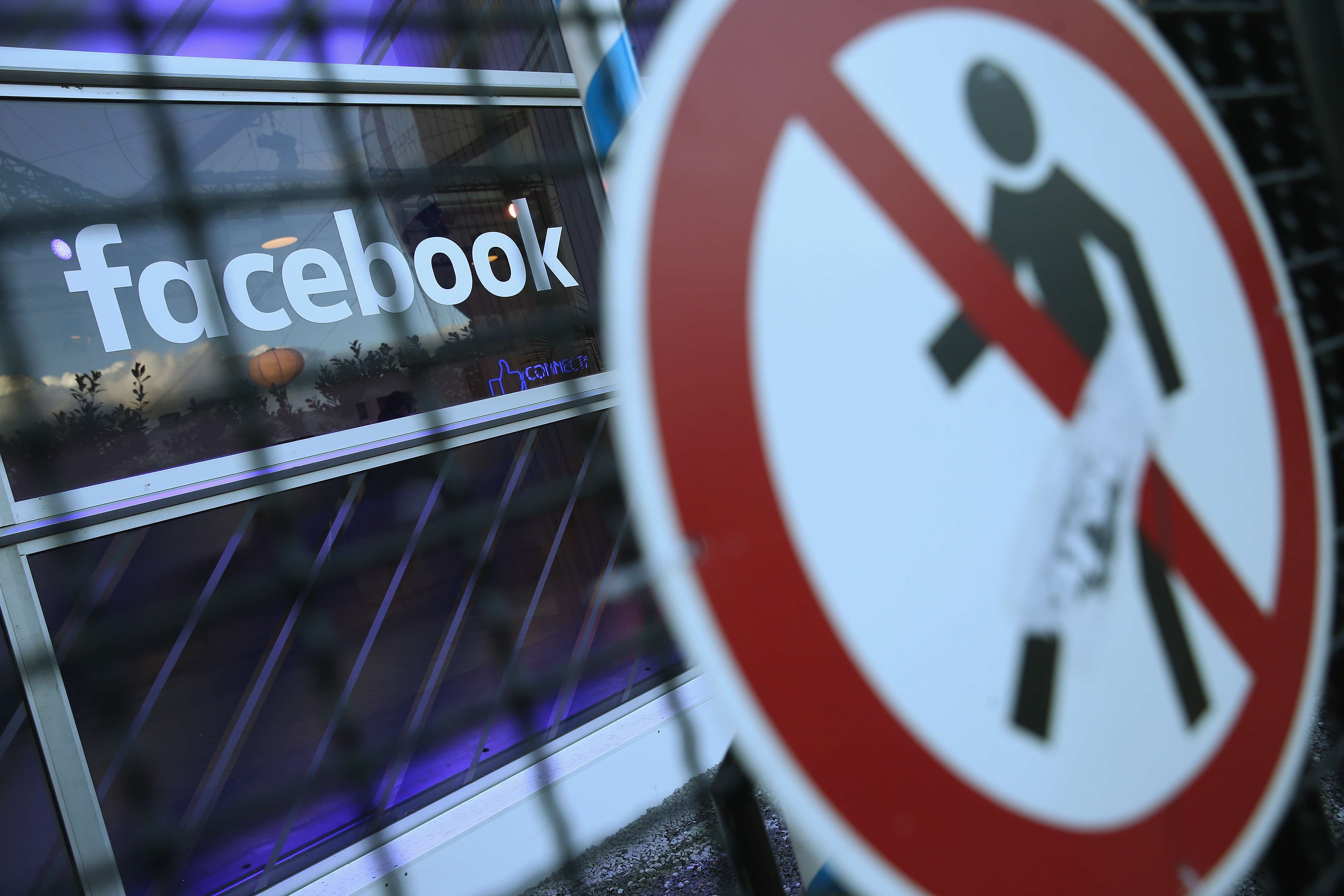 A no entry symbol hangs on an opened gate next to the Facebook logo at the Facebook Innovation Hub on February 24, 2016 in Berlin, Germany. The Facebook Innovation Hub is a temporary exhibition space where the company is showcasing some of its newest technologies and projects.