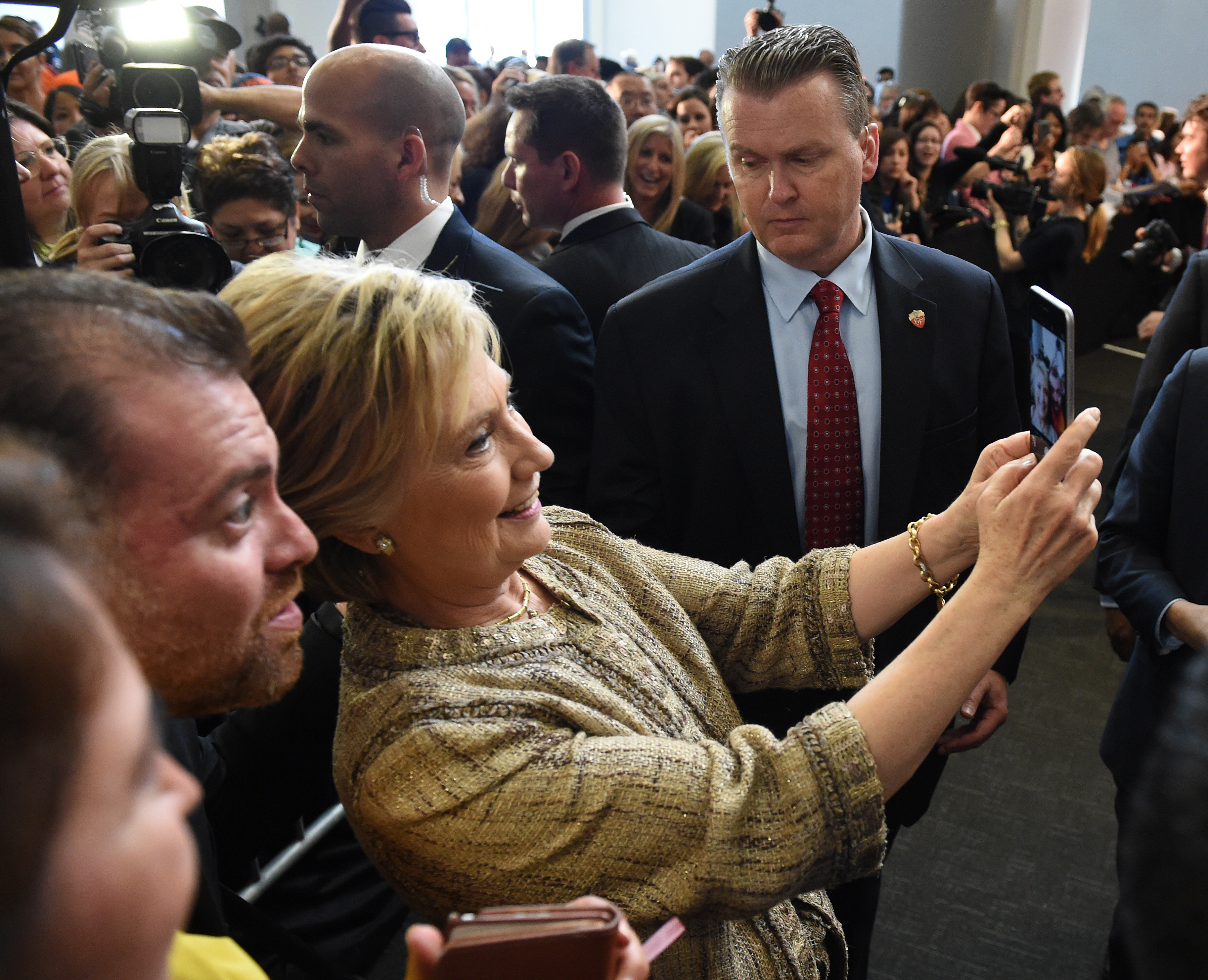 Hillary Clinton takes a selfie with a fan during a campaign rally at the Southwest College