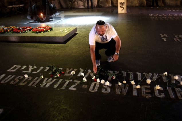 An Israeli relative of Holocaust victims lays a flower at the Hall of Remembrance where the names of major death and concentration camps are written during a ceremony marking the annual Holocaust Remembrance Day at the Yad Vashem Holocaust Memorial in Jerusalem on May 5, 2016.