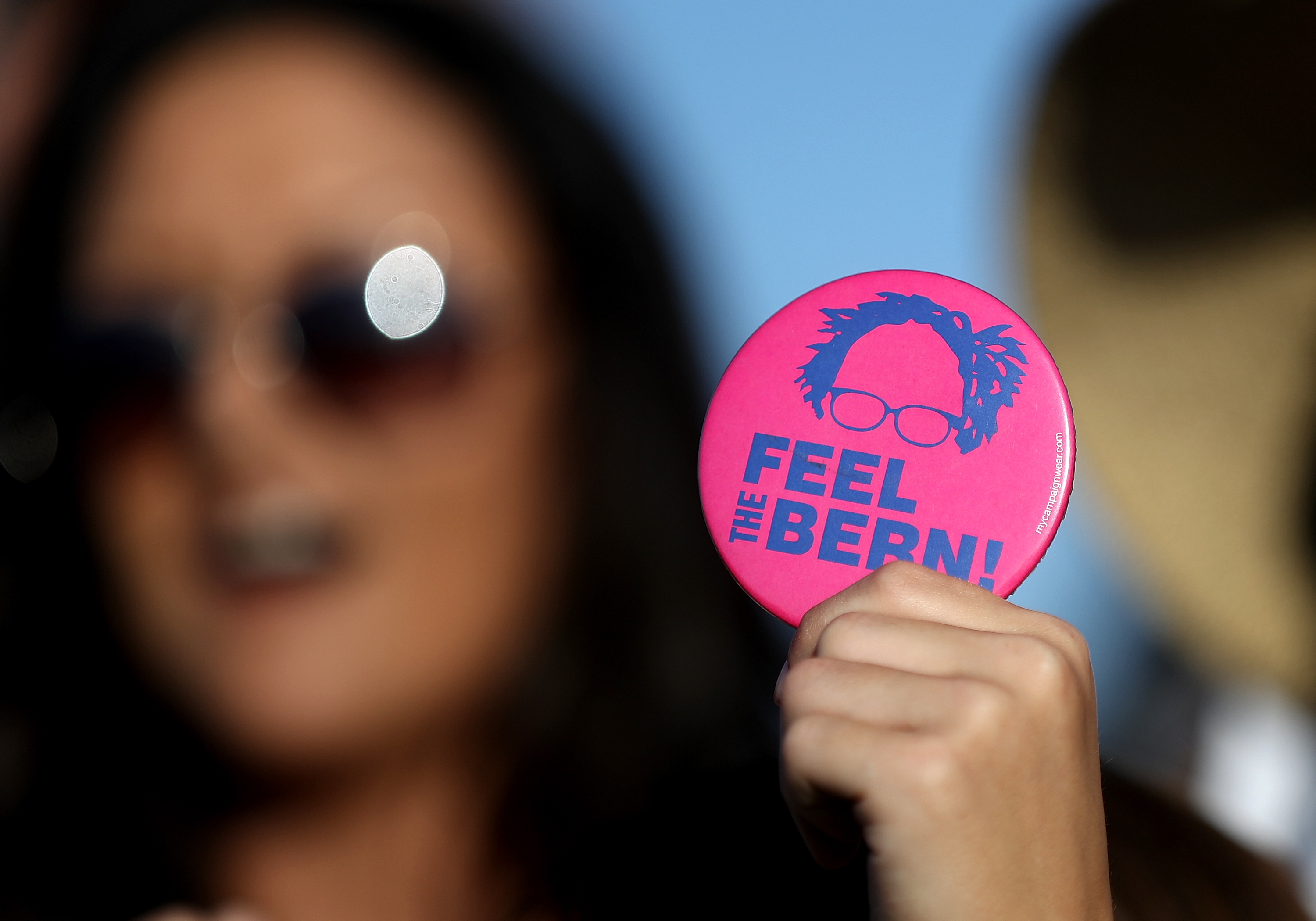 A supporter of democratic presidential candidate Sen. Bernie Sanders holds a campaign button during a campaign rally at Waterfront Park on May 18, 2016 in Vallejo, California. A day after wining the Oregon primary, Bernie Sanders is campaigning in California ahead of the state's presidential primary on June 7.