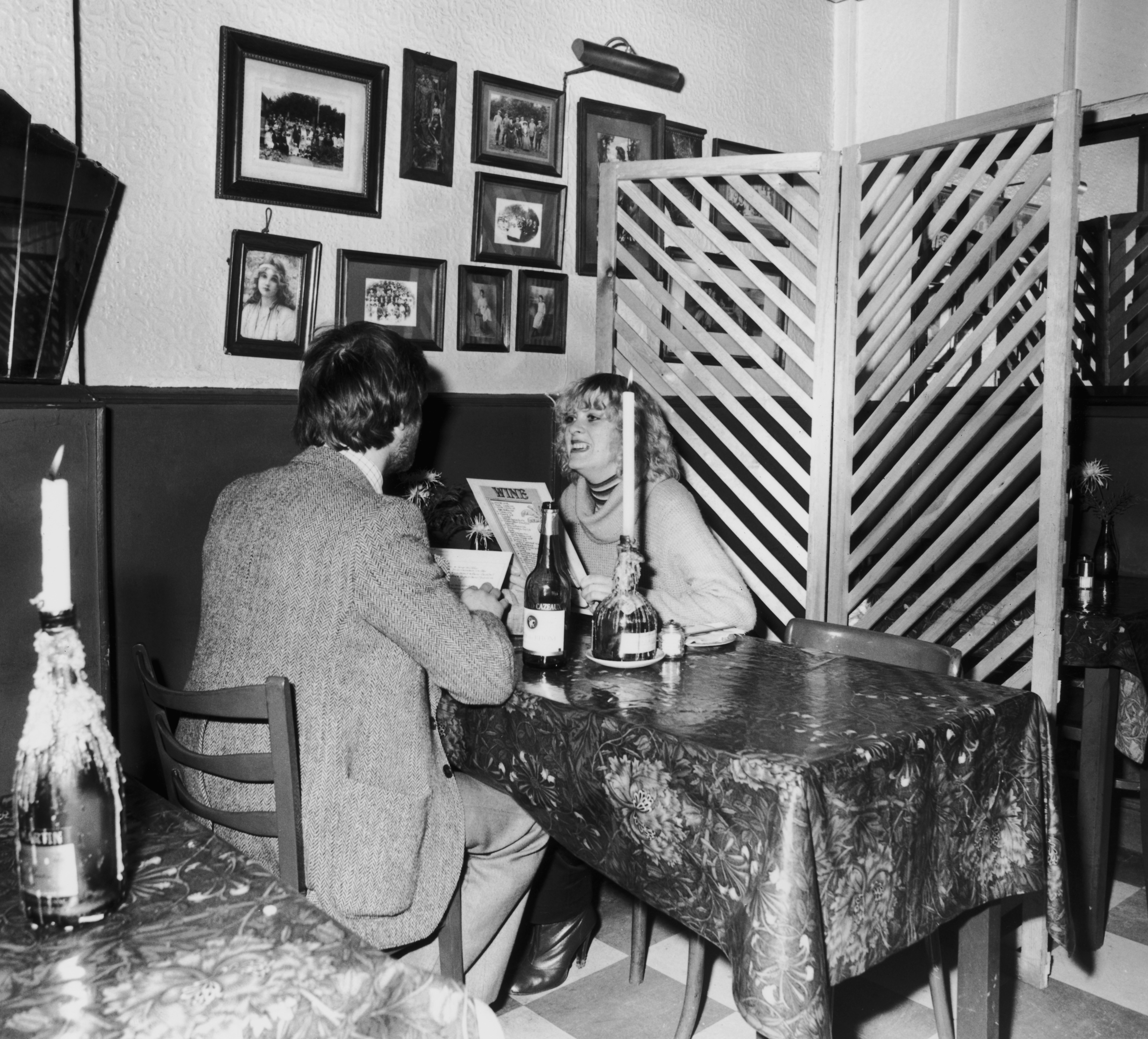 A couple enjoying a dinner date by candlelight in a restaurant, late 1970s.